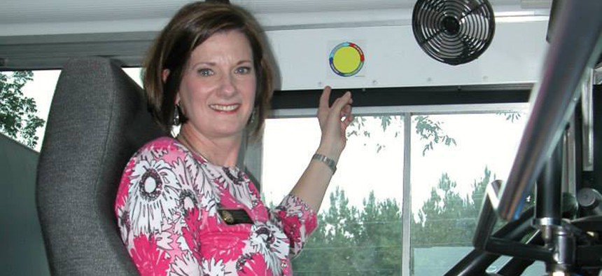 Lora Weaver of the Northeast Alabama Traffic Safety Office points to a yellow dot inside an Autauga County school bus.