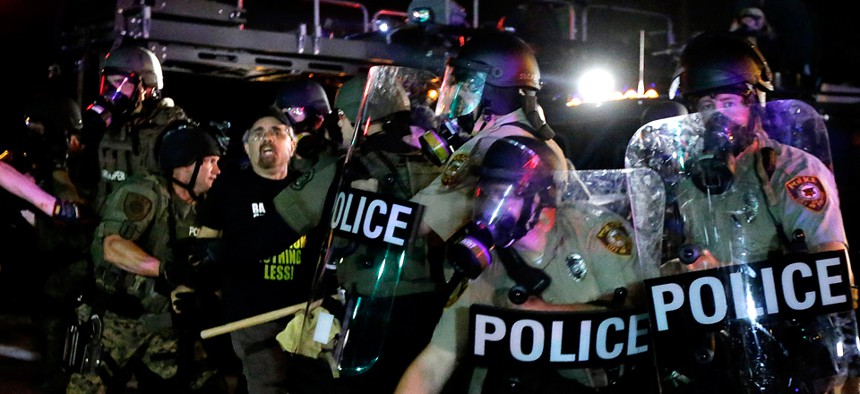 A man is detained after a standoff between protesters and police Monday in Ferguson.