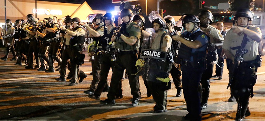 Police advance during a protest in Ferguson on Aug. 18. 