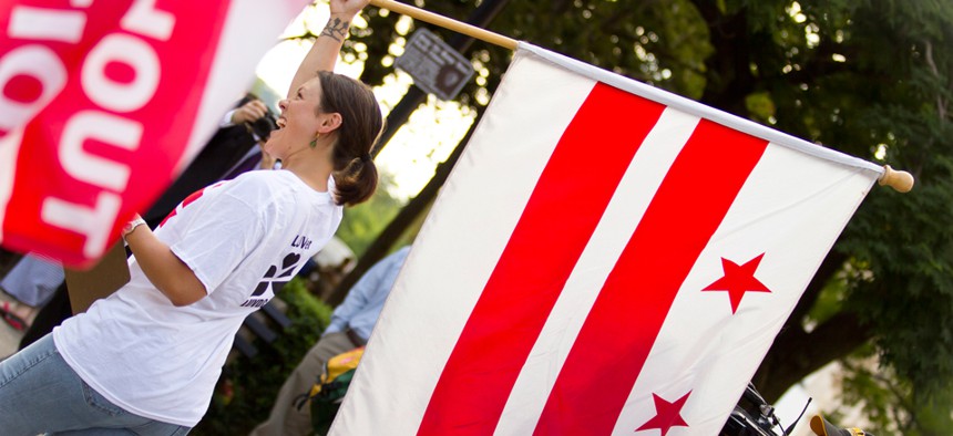 An attendee supporting statehood carries a DC flag during an event in 2012.