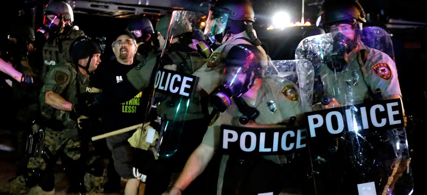 Police detain a man Aug. 18 during a protest in Ferguson.