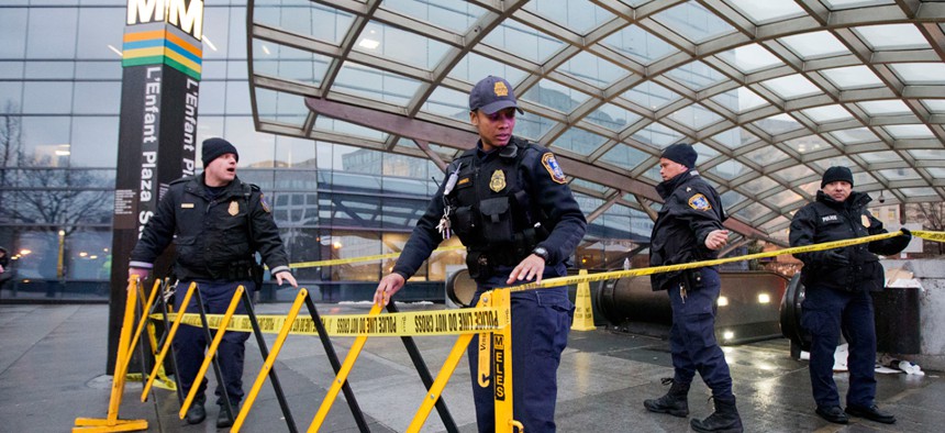 Metro Transit Police  officers secure the entrance to L'Enfant Plaza Metro station Monday.
