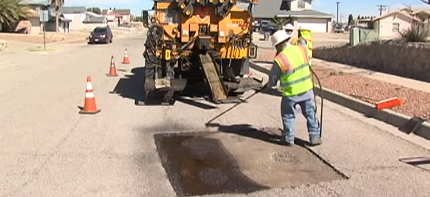 An El Paso work crew repairs a pothole on a residential street.