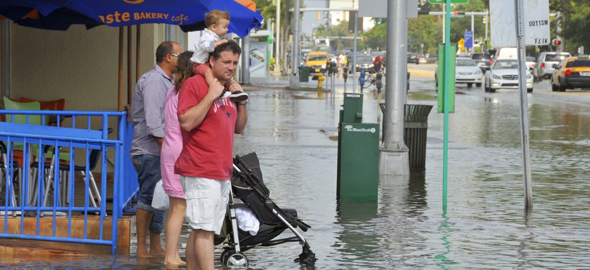 People in Miami Beach's South Beach area wade through high water in October 2012.
