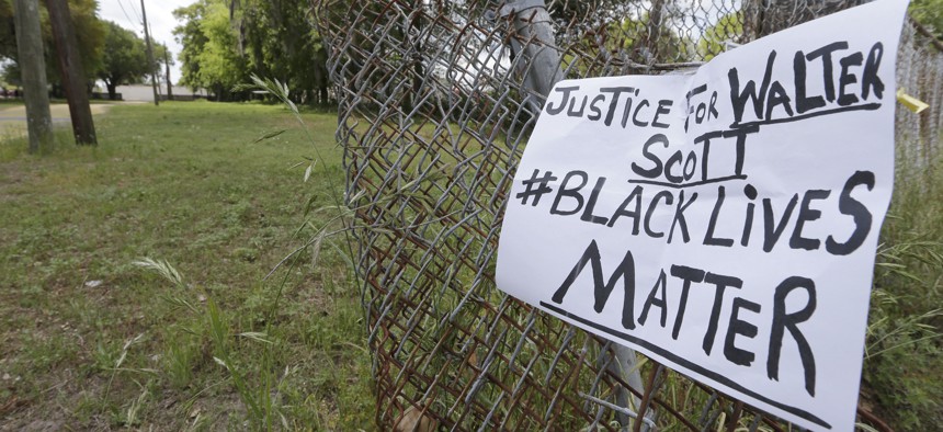 A sign calling for justice is attached to a fence near the site where Walter Scott was killed in North Charleston, S.C.