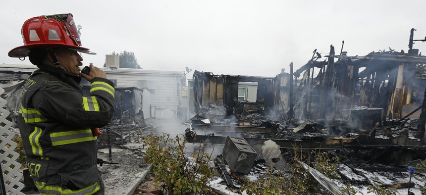 Napa Fire Captain Steve Becker inspects mobile homes which were destroyed Sunday, Aug. 24, 2014, at the Napa Valley Mobile Home Park, in Napa, Calif.