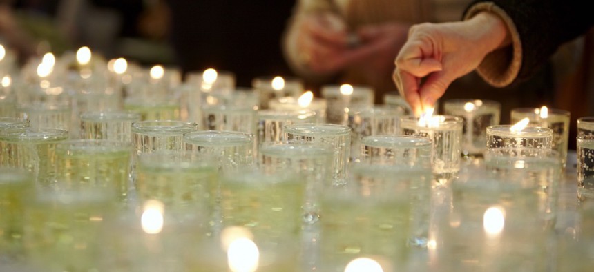 Candles are lit at an Orthodox Jewish funeral. The group is one of several that objects to autopsies on religious grounds.