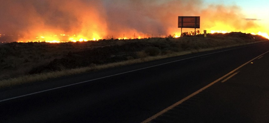 A fire burns land along State Route 14 near Roosevelt, Wash., on Aug. 4, 2015. 