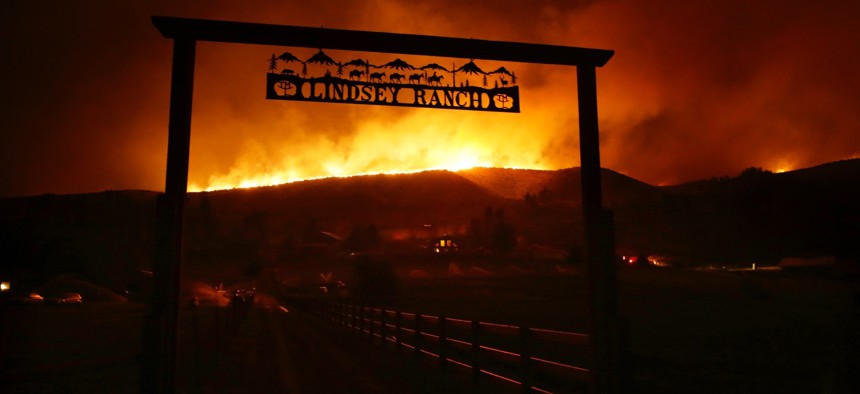 Fire burns on the ridge above a ranch on Twisp River Road in Twisp, Wash., Wednesday, Aug. 19, 2015. Authorities on Wednesday afternoon urged people in the north-central Washington town to evacuate because of a fast-moving wildfire.