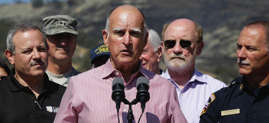 Gov. Jerry Brown, center, speaks next to Mark Ghilarducci, director of the California Governor’s Office of Emergency Services, left, and Cal Fire Chief Ken Pimlott, right, at a news conference near Clearlake, Calif., Aug 6, 2015.