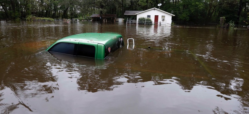 A vehicle and a home are swamped with floodwater from nearby Black Creek in Florence, S.C., Monday, Oct. 5, 2015 as flooding continues throughout the state following several days of rain.
