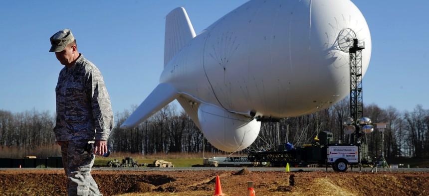 NORAD's Air Force Col. Chuck Douglass walks in front of an unmanned aerostat that is part of a new U.S. military cruise-missile defense system during a media preview, Wednesday, Dec. 17, 2014, in Middle River, Md.