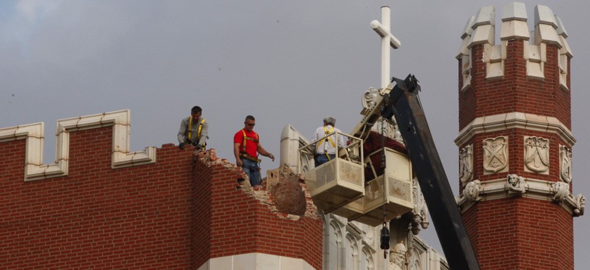 Maintenance workers inspect damage to Benedictine Hall at St. Gregory's University in Shawnee, Oklahoma, on Nov. 6, 2011. Two earthquakes in less than 24 hours caused a tower to topple and damaged the other three.