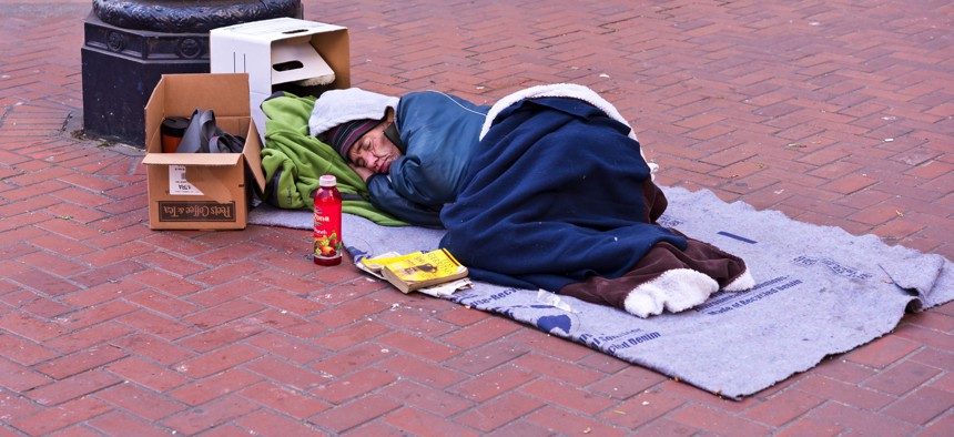 A homeless man sleeps on Market Street in San Francisco.