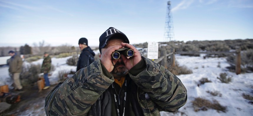 Sean Anderson, a supporter of the group that occupied the Malheur National Wildlife Refuge, looks through binoculars at the front gate on Jan. 6 near Burns, Ore.