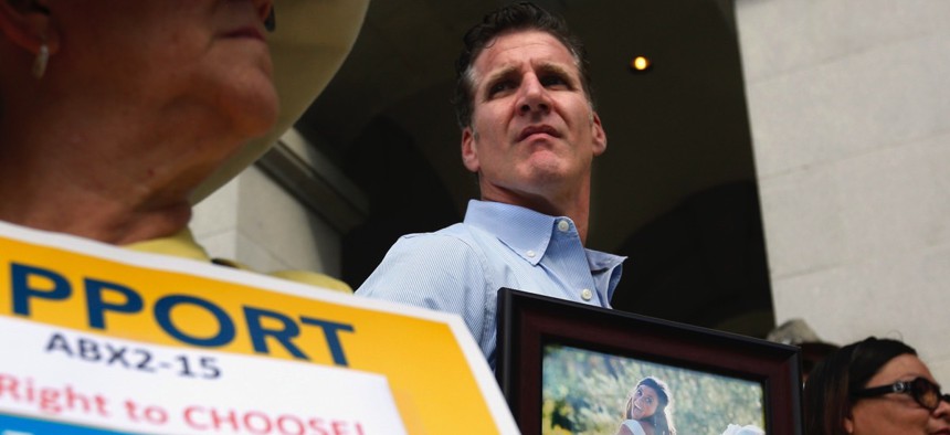 Dan Diaz holds a photo of his late wife, Brittany Maynard, during a rally calling for California Gov. Jerry Brown to sign the right-to-die legislation at the Capitol in Sacramento, Calif. on Sept. 24.