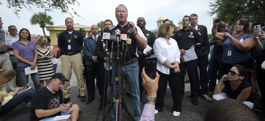 Orlando Mayor Buddy Dyer addresses reporters while flanked by members of law enforcement and community leaders during a news conference after a shooting involving multiple fatalities at a nightclub in Orlando, Fla., on Sunday.