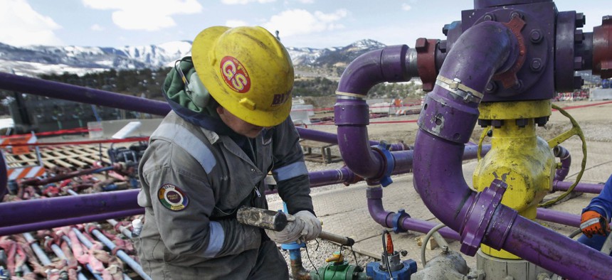 Workers tend to a well head during a hydraulic fracturing operation at an oil and natural gas extraction site, outside Rifle, on the Western Slope of Colorado. 