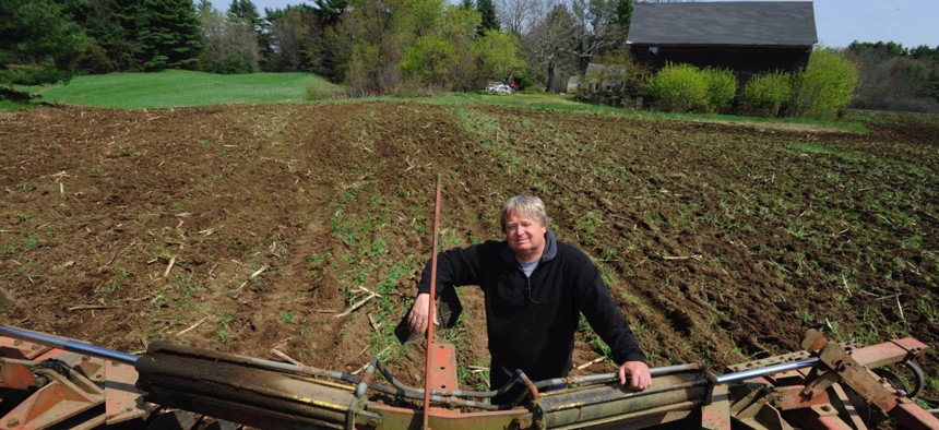 Peter Orr stands behind a harrow used to till his land on his farm in Thompson, Connecticut.