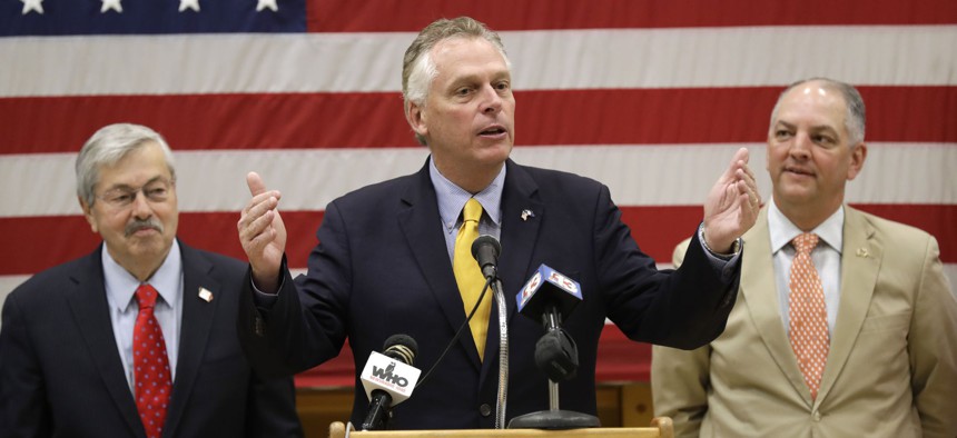 Virginia Gov. Terry McAuliffe, center, speaks during a news conference as Iowa Gov. Terry Branstad, left, and Louisiana Gov. John Bel Edwards, right, look on, Friday, July 15, 2016, at EFCO Corp. in Des Moines, Iowa.