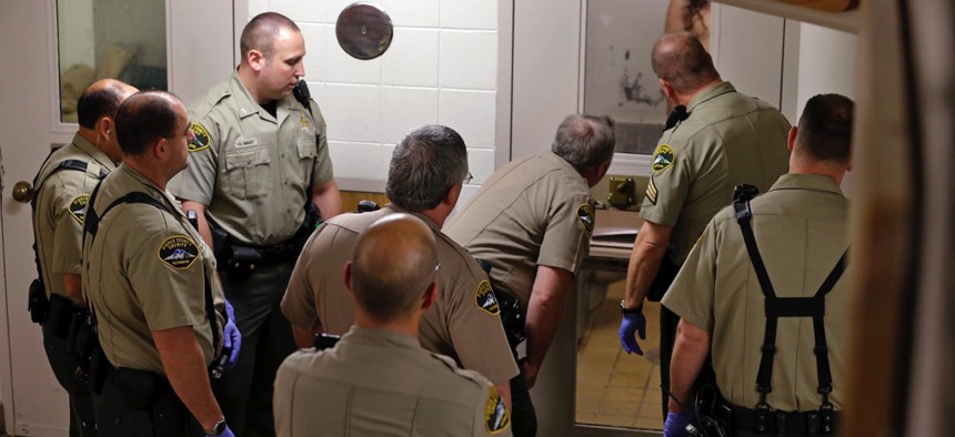 Corrections deputies prepare to enter a cell in the psychiatric unit of the Pierce County Jail in Tacoma, Washington.