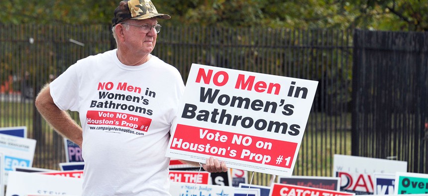 A demonstrator holds a sign against the Houston Equal Rights Ordinance outside an early voting center in Houston in 2015.