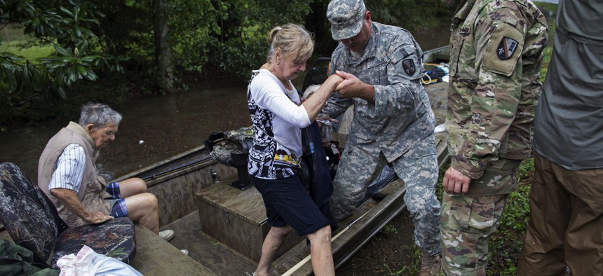 Members of the Louisiana Army National Guard rescue people from rising floodwater near Walker, La.
