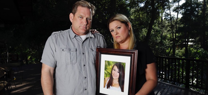 Larry Pott, left, and his wife Lisa pose for a portrait holding a picture of their daughter Audrie in Saratoga, Calif. Audrie Pott committed suicide in September 2012 after being sexually assaulted by three boys during a house party in Saratoga.
