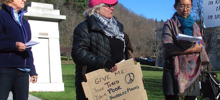 Crystal Zevon, center, holds a sign on Nov. 20, 2015, at a rally outside the Statehouse in Montpelier, Vt., where she supported bringing resettling Syrian refugees.