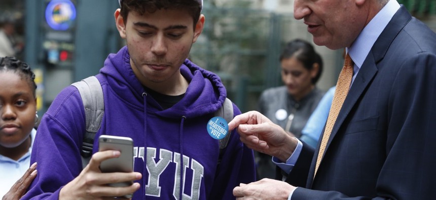 NYC Mayor Bill de Blasio helps citizens register to vote.