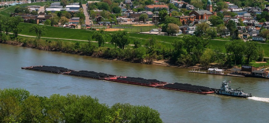 A coal barge floats past Dayton, Kentucky.