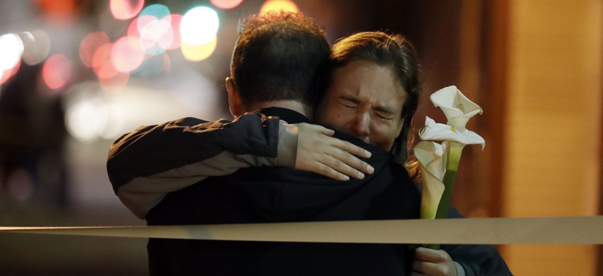 Mourners embrace near the site of Friday night's warehouse fire in Oakland, Calif.
