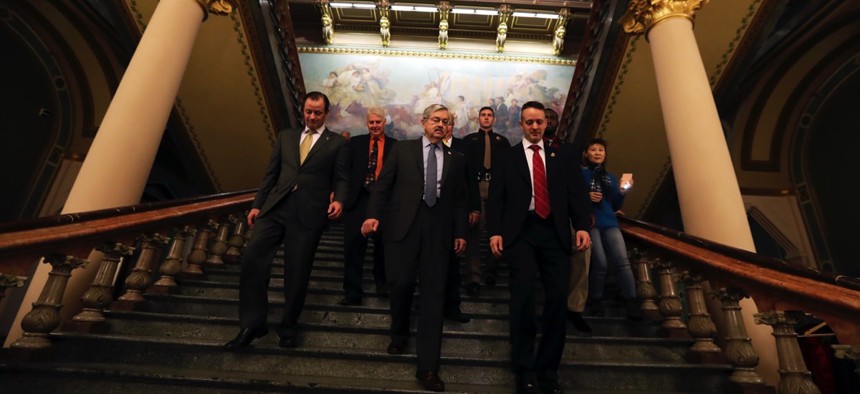 Iowa Gov. Terry Branstad, center, is escorted back to his office after delivering his annual condition of the state address before a joint session of the Iowa Legislature on Tuesday.