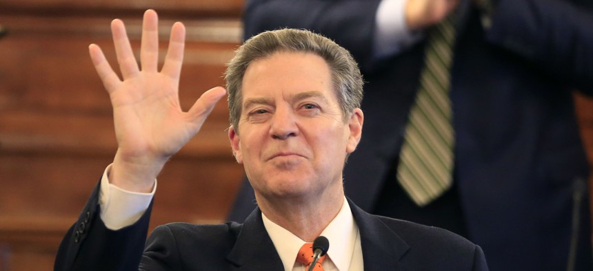 Gov. Sam Brownback waves to guests before delivering his state of the state address to a joint session of the Kansas legislature in Topeka, Kan., Tuesday, Jan. 10, 2017.