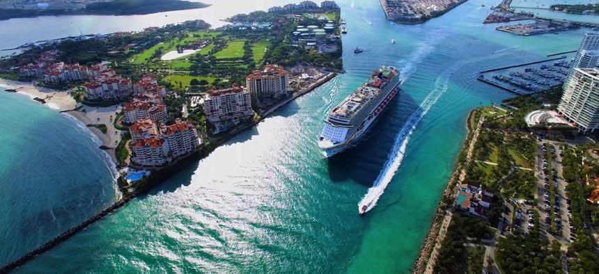 A cruise ship exits Miami into the Atlantic Ocean via the Government Cut canal.