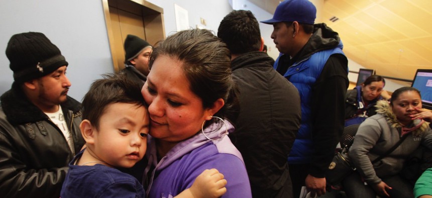 Veronica Ramirez, originally from Mexico, holds her 15-month-old son, Lora, as she waits in line to apply for a municipal identification card in New York City.