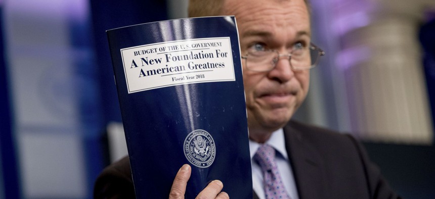 Budget Director Mick Mulvaney holds up a copy of President Donald Trump's proposed fiscal 2018 federal budget.