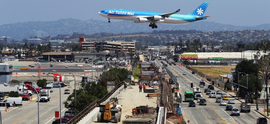 An airliner prepares to land at Los Angeles International Airport over the Metro Crenshaw/LAX Line, en extension of the city's transportation network as the city seeks the 2024 Summer Olympic Games.