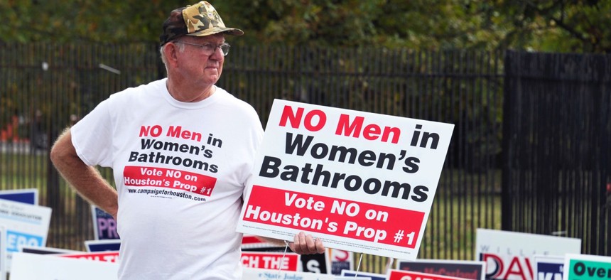 A demonstrator holds a sign against the Houston Equal Rights Ordinance outside an early voting center in October 2015.