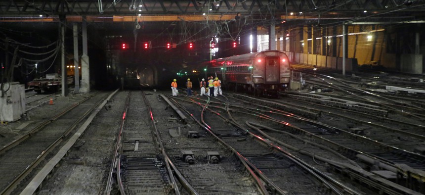 Workers near an outbound train on the tracks under New York's Penn Station on Monday, Aug. 17, 2015.