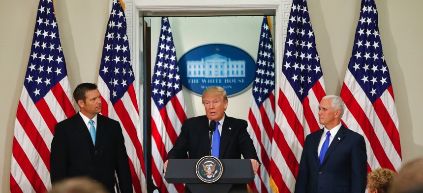 President Donald Trump, with Kansas Secretary of State Kris Kobach, left, and Vice President Mike Pence, right, speaks at a meeting of the Presidential Advisory Commission on Election Integrity on Wednesday at the White House.