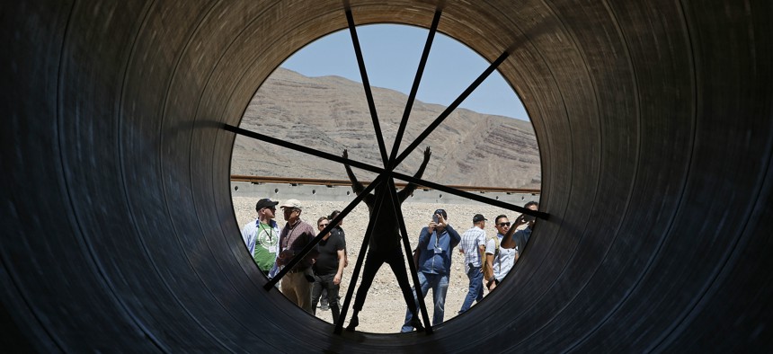 People stand in a metal tube after a test of a Hyperloop One propulsion system, Wednesday, May 11, 2016, in North Las Vegas, Nev.