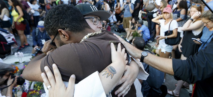 Brittney Cain-Conley, lead organizer for Congregate Charlottesville, with hat, gets a hug from a supporter after she addressed the crowd during a vigil on Sunday, Aug. 13, 2017
