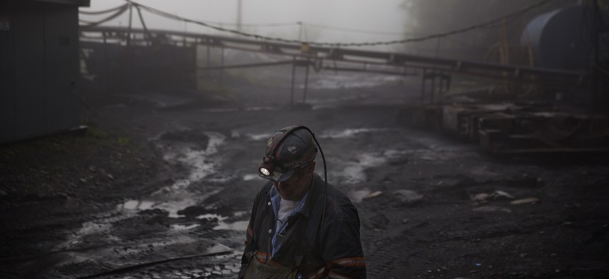 A coal miner walks through the morning fog in Welch, W.Va. in May of 2016.