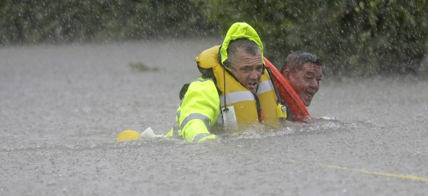 Wilford Martinez, right, is rescued from his flooded car along Interstate 610 in floodwaters from Tropical Storm Harvey on Sunday, Aug. 27, 2017, in Houston, Texas.