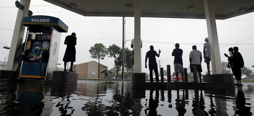 People watch heavy rain caused by Harvey from the relative safety of a flooded gas station on Sunday, Aug. 27, 2017, in Houston. 