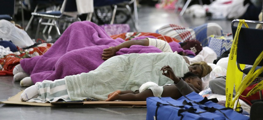 People sleep on the floor at the George R. Brown Convention Center that has been set up as a shelter for evacuees escaping the floodwaters from Tropical Storm Harvey in Houston, Texas, Tuesday, Aug. 29, 2017. 