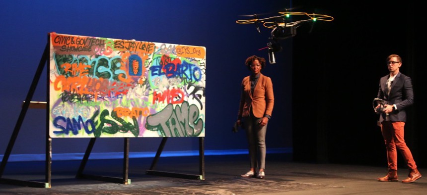 Candace Marbury and Christopher Farmer, cofounders of GRAD, demo their graffiti-cleaning drone.