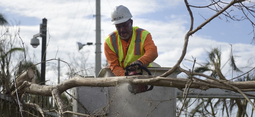 A Liberty Cable worker cuts branches to restore fiber optic lines three days after the impact of Hurricane Maria in Carolina, Puerto Rico