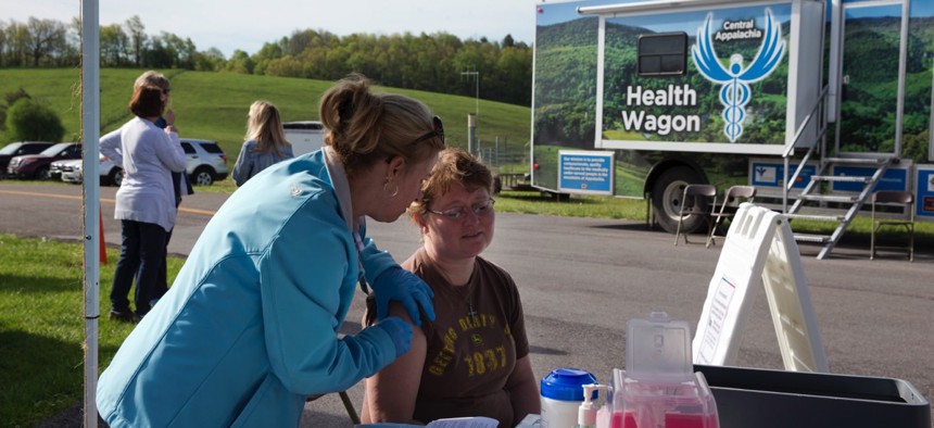 Monica Hicks, 47, of Meadowview, Va., gets a free flu shot after receiving new glasses during the first Remote Area Medical (RAM) clinic in Smyth County, Va.